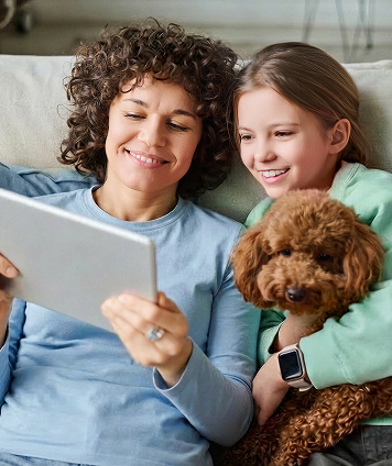 Matka s dcérou sa usmievajú a držia v ruke tablet