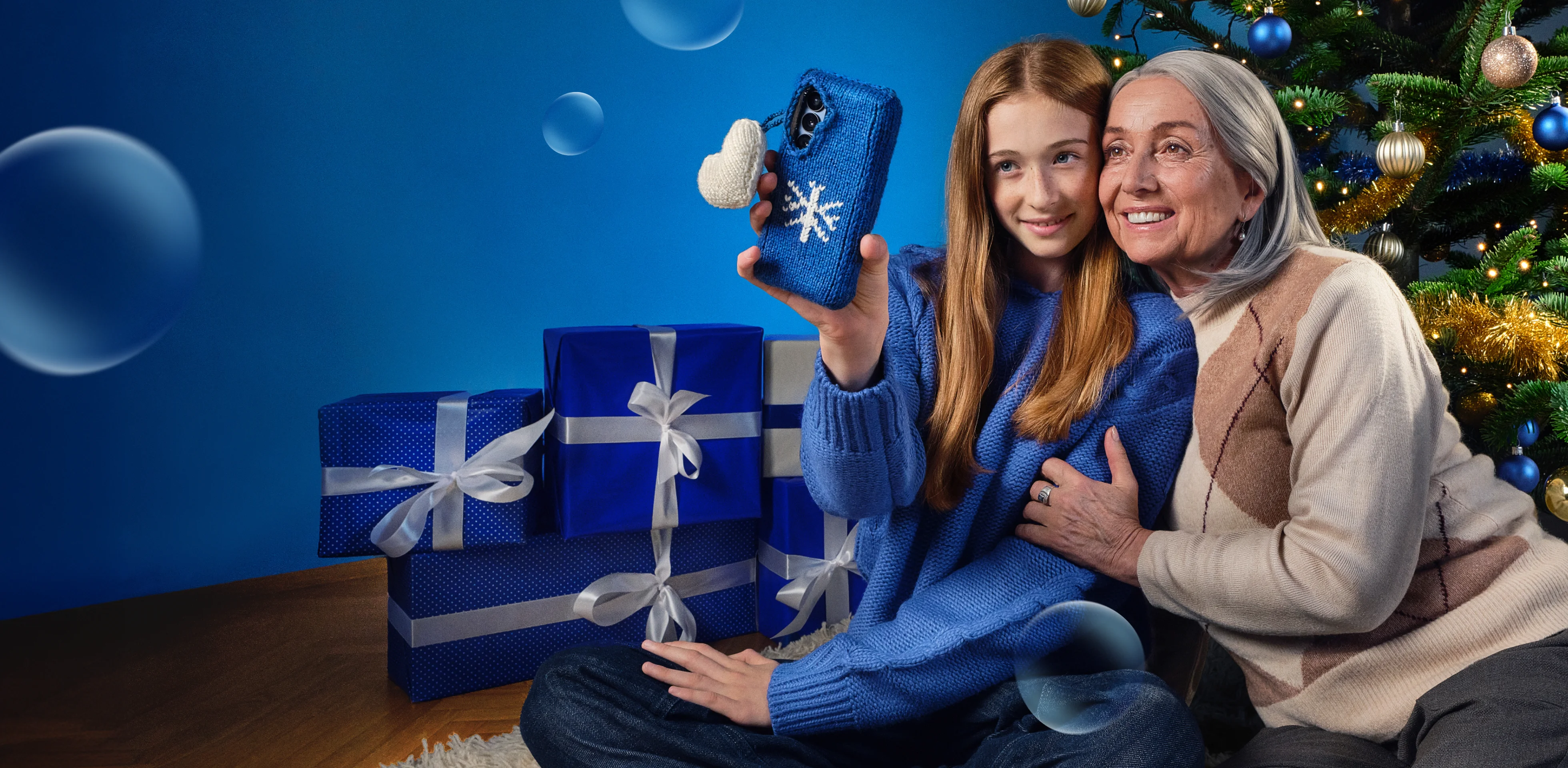 Dievča a stará mama si pri vianočnom stromčeku robia selfie