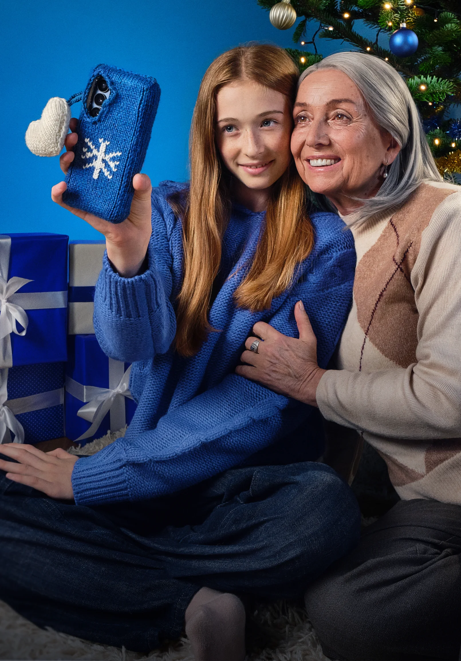 Dievča a stará mama si pri vianočnom stromčeku robia selfie